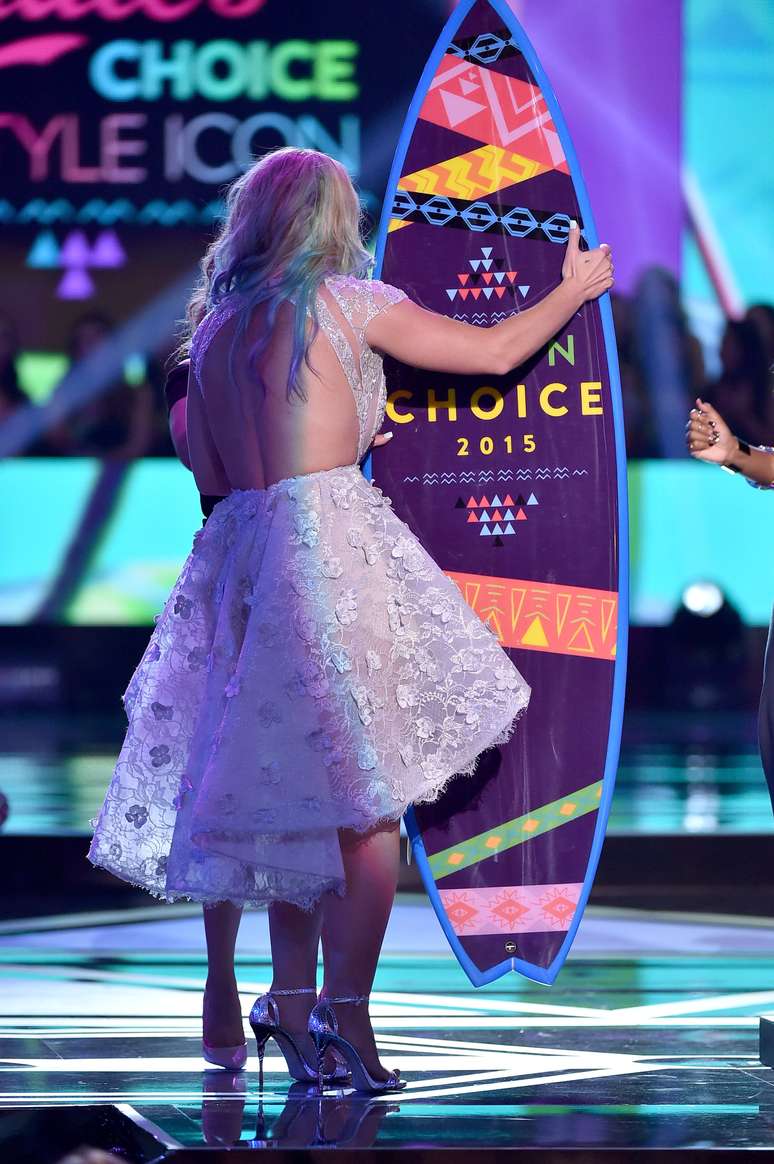 Vendo de trás, com as costas à mostra, parece que Britney está meio apertada no modelito, cujo corte da saia amplia demais os quadris. 