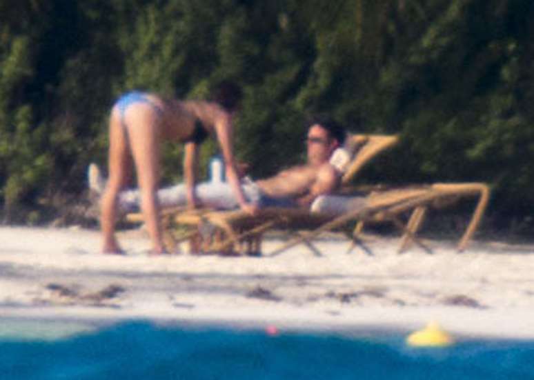 Jennifer Aniston pratica ioga, enquanto Justin Theroux observa o mar sentado