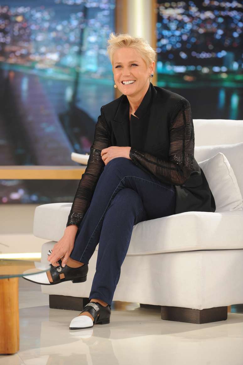 Xuxa aposta no look informal, misturando blazer com manga de detalhes transparentes, calça jeans e sapatos baixos bicolores