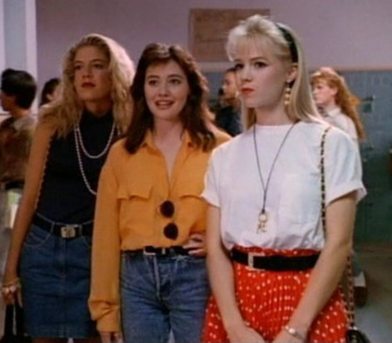 A atriz Shannen Doherty interpretando Brenda (ao centro) em &#034;Barrados no Baile&#034;, ao lado das amigas Kelly Taylor (Jennie Garth, à dir) e Donna (Tori Spelling) 