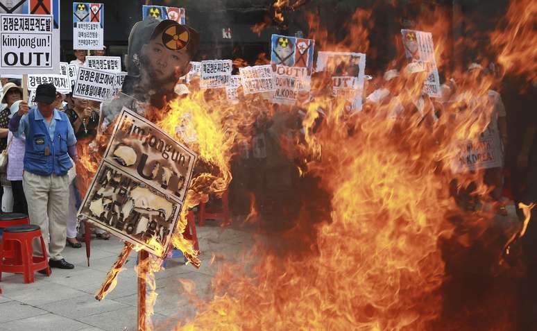 Ativistas sul-coreanos queimam cartazes com o rosto de Kim Jong-un durante um protesto contra a Coreia do Norte em Paju