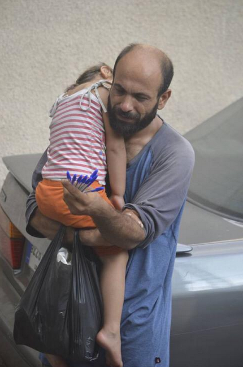 Foto de Abdul vendendo canetas com a filha no colo foi compartilhada milhares de vezes