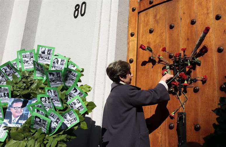 Senadora e filha do presidente Salvador Allende, Isabel Allende, deposita flores na porta lateral do Palácio de La Moneda.