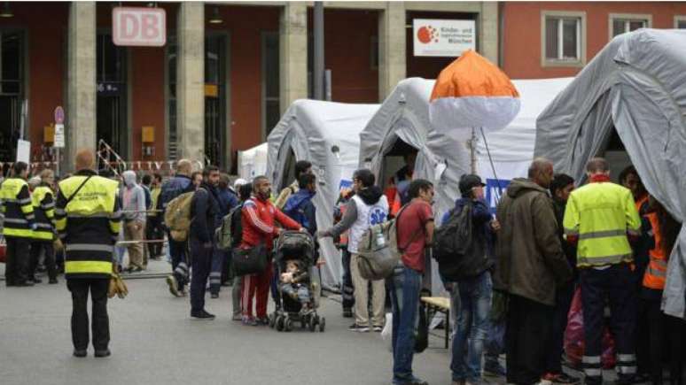 Imigrantes passam por um check-up médico na chegada a Munique