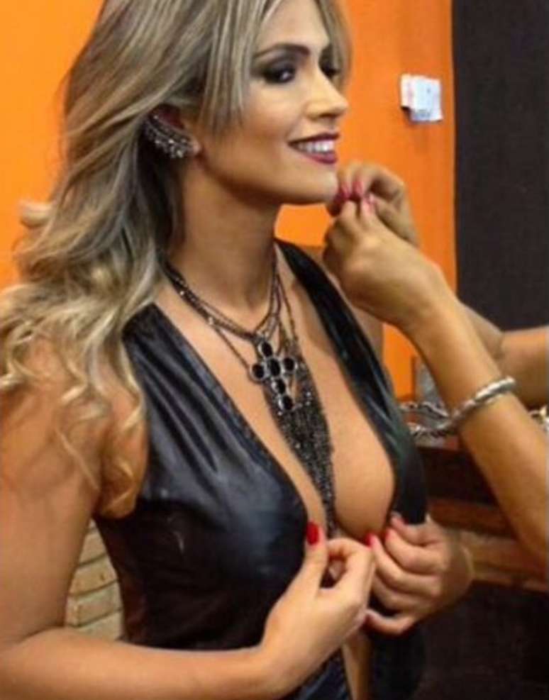 Nessa foto, Fani at&eacute; coloca a m&atilde;o no decote para valorizar a regi&atilde;o. Veja como a abertura chega at&eacute; o umbigo. Melhor, n&atilde;o!