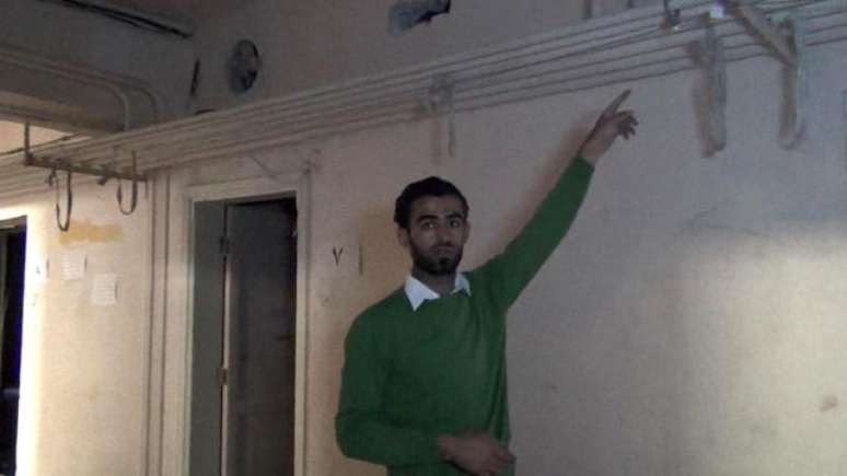 Milad Al-Shihaby com as cordas que eram usadas para pendurar os prisioneiros