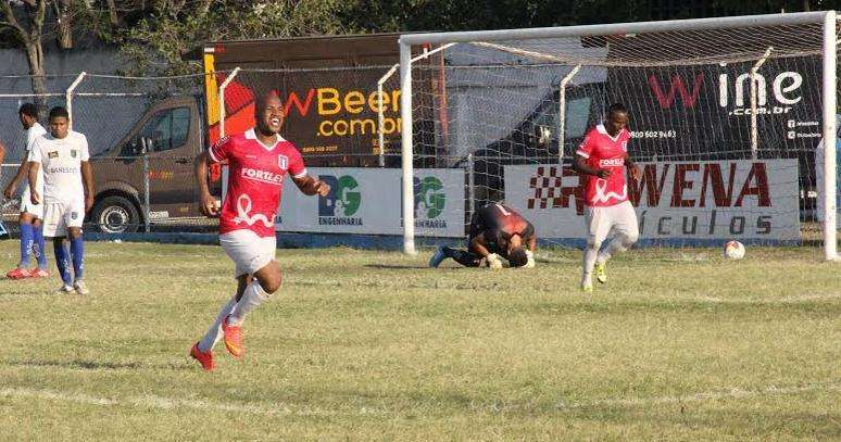 Jogador do ESFC comemora gol na partida em que o time usou camosa cor de rosa
