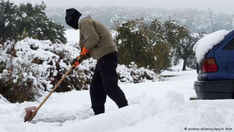 Homem retira neve da entrada de sua casa em Hünstetten, no estado de Hessen