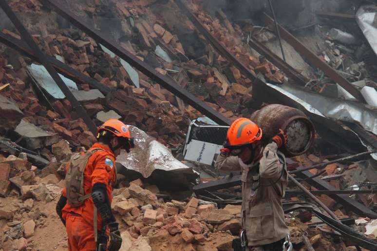 Bombeiro retira botijão de gás do local da explosão no Rio.