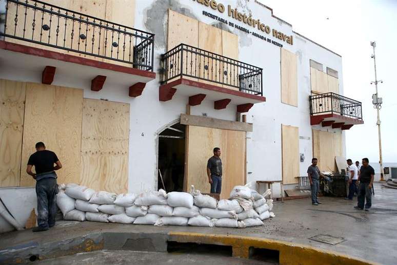 Habitantes da zona turística de Puerto Vallarta, no estado de Jalisco, protegem suas casas e comércios antes da chegada do furacão