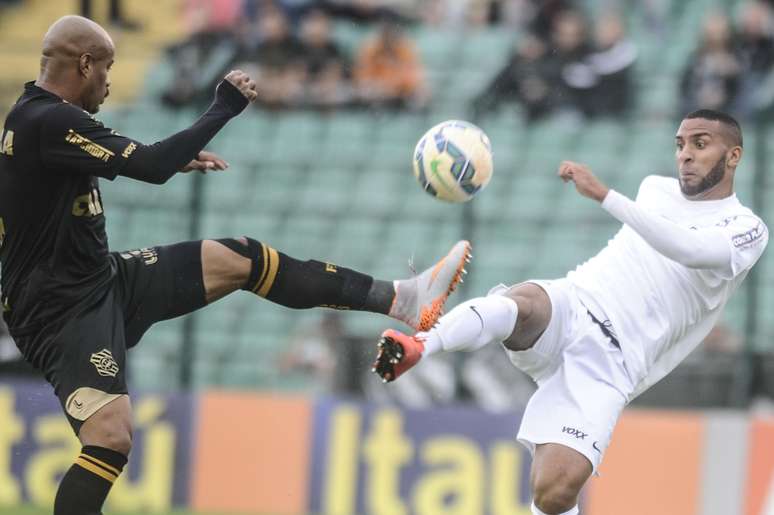 Atletas de Santos e Figueirense disputam bola em partida válida pela 32ª rodada do Campeonato Brasileiro.