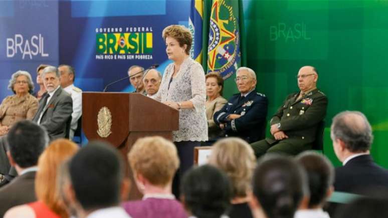 Presidente Dilma Rousseff é observada por comandantes militares em cerimônia no Planalto em dezembro de 2014; governos civis fazem &#039;pacto de silêncio&#039; sobre violações na ditadura, avalia autor