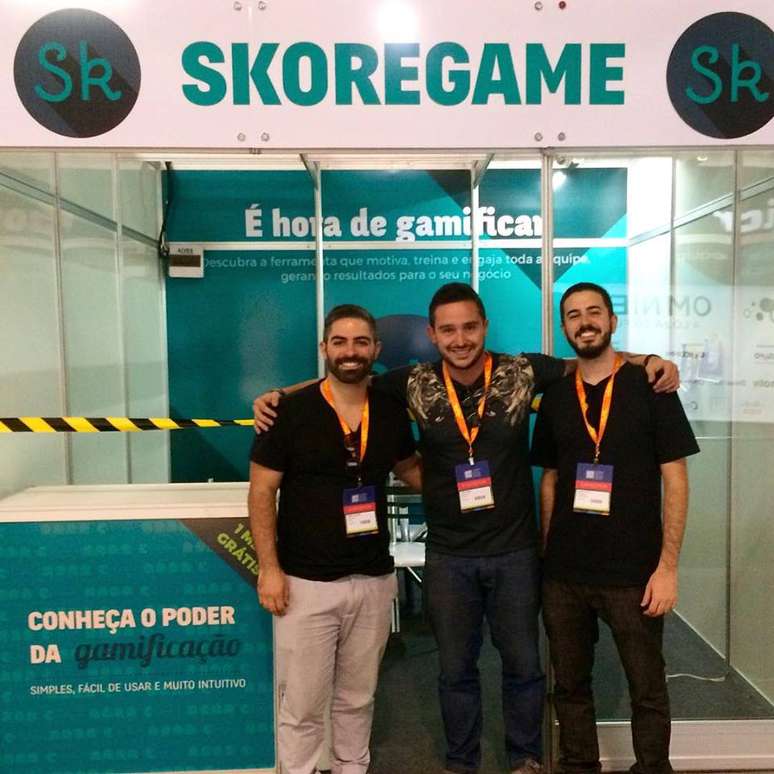 Gabriel Falcione (à esquerda), fundador da startup criadora da Skoregame, à frente de um estande da vendas da plataforma