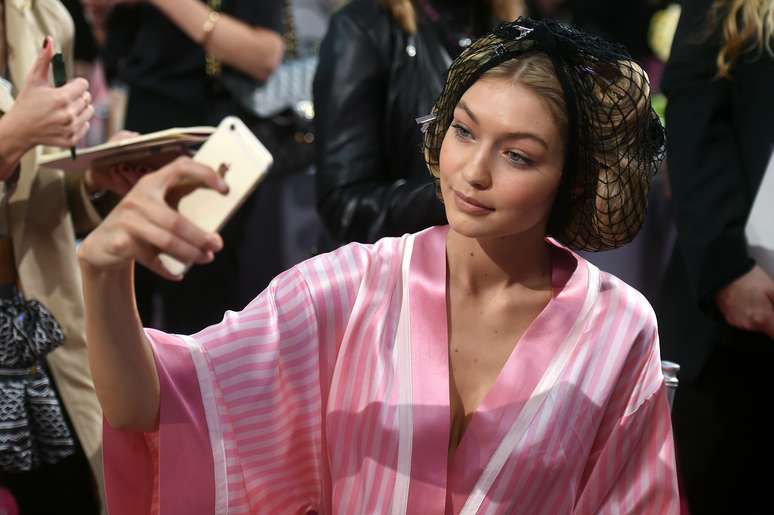 Gigi Hadid tira selfie no celular enquanto espera desfile