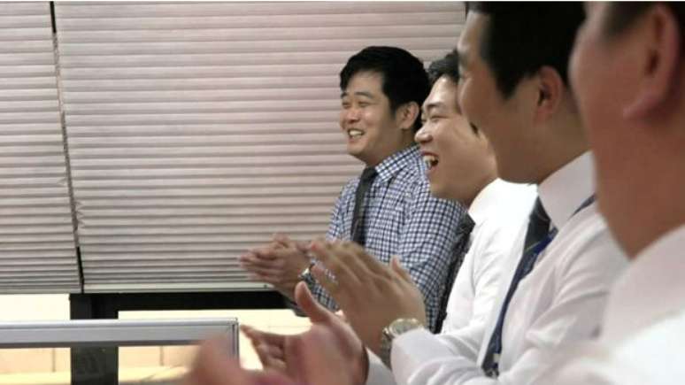 Funcion&aacute;rios participam de roda de risos antes do in&iacute;cio dos trabalhos