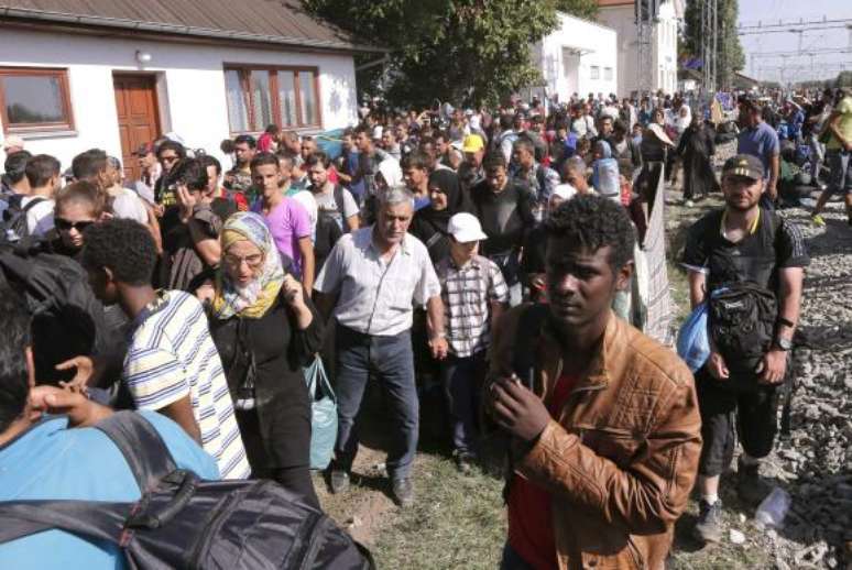 Migrantes que cruzaram fronteira da Sérvia com a Croácia aguardam em campo para fazer registro