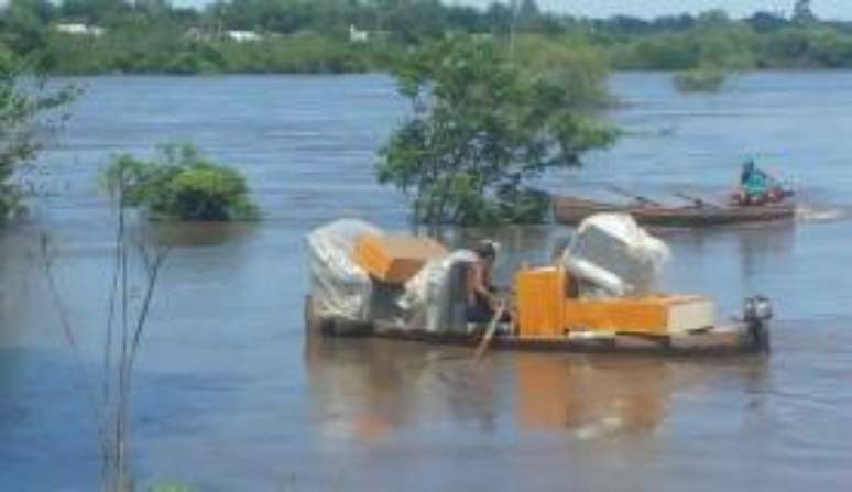 Moradores usam barcos para se locomover nas áreas afetadas   
