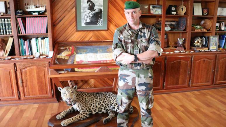 Coronel Jérôme Ransan em seu escritório com leopardo embalsamado e bandeira do terceiro Regimento estrangeiro de infantaria, que comanda na Guiana Francesa