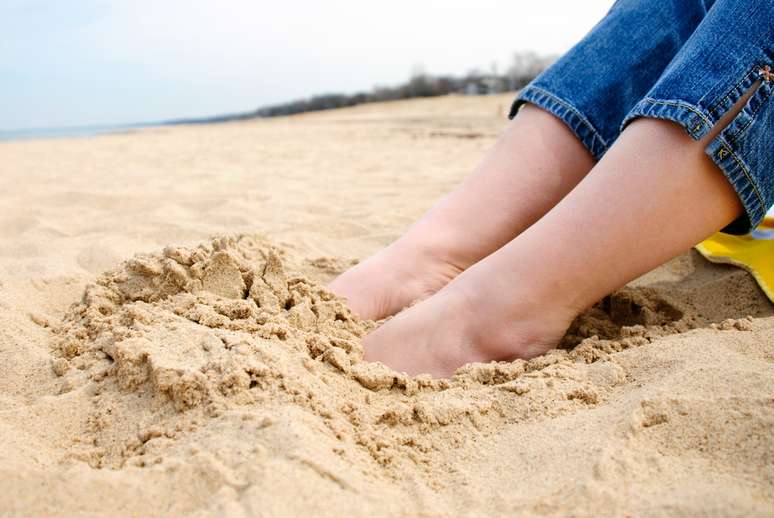 Caminhar descalço na areia é bom exercício para prevenir joanetes.