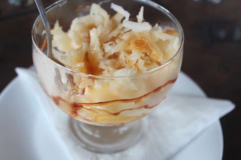 O coco é uma fruta bastante utilizada na culinária local. Na foto, sobremesa do Uíki Parracho, em Arraial d'Ajuda - sorvete de creme com cocada