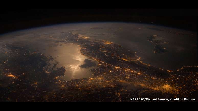Os 77 trabalhos representam o que humanos veriam se fossem visitar esses lugares. Nesta imagem, Terra sendo vista a partir da Estação Espacial Internacional. A bota da Itália fica claramente visível. No canto inferior direito, as luzes são de Milão.  