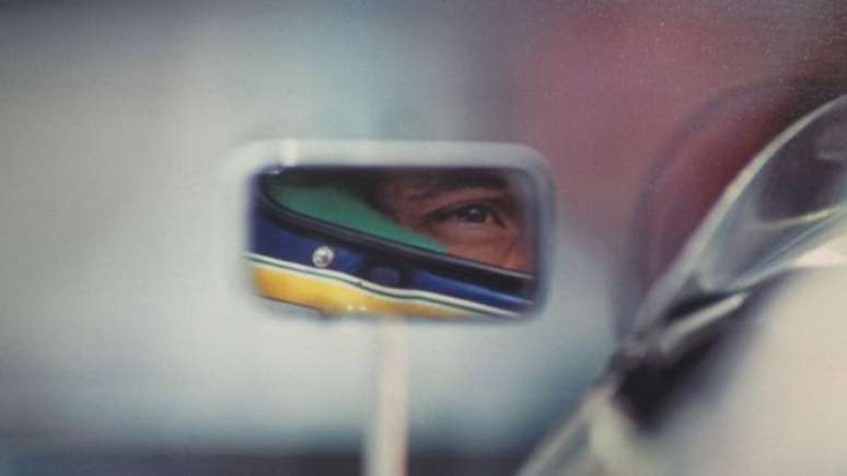 Senna pelo retrovisor de seu carro em Suzuka, no GP do Japão, em 1991, onde venceria seu terceiro título mundial. Para seu autor, Ercole Colombo, é o símbolo da exposição: &#039;É como se Senna olhasse a sua história pelo retrovisor&#039; 