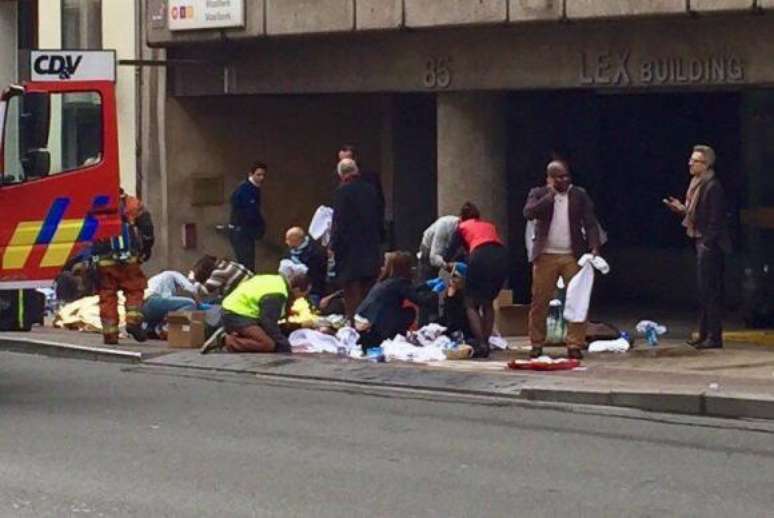 Equipes de emergência socorrem feridos em frente à estação Maelbeek do metrô, em Bruxelas