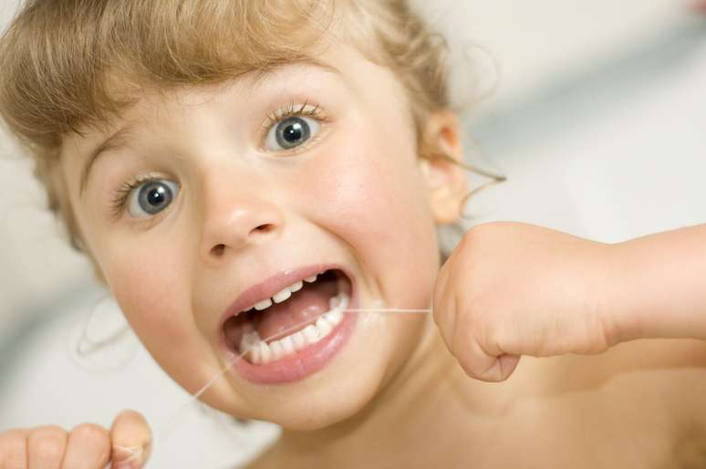 Mesmo que a criança só tenha um dente, a mamãe deve passar o fio nas laterais e na parte que faz contato com a gengiva a fim de remover resíduos 