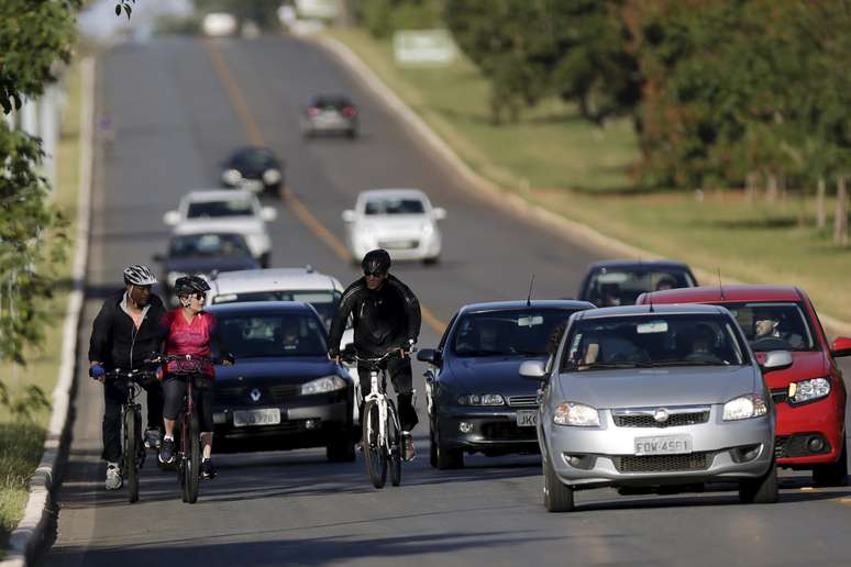 Presidente do Brasil Dilma Rousseff monta sua bicicleta acompanhados por seguranças perto do Palácio da Alvorada, em Brasília