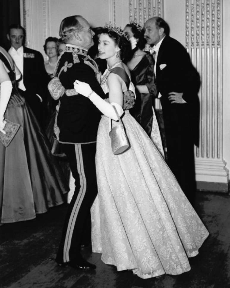 Rainha Elizabeth II dançando com Marechal Sir John Baldwin (1892 - 1975) em um baile realizado no Hyde Park Hotel, Londres, em 26 de novembro de 1954.