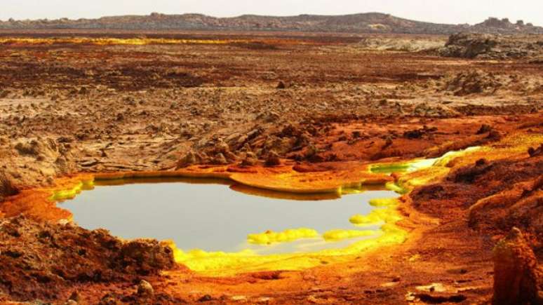 Sistema hidrotermal na depressão de Danakil, na África. Depósitos amarelos são uma variedade de sulfatos, e as áreas vermelhas são óxidos de ferro 