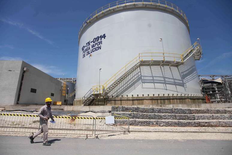 Operário passa na frente de um dos tanques da petroquímica mexicana.