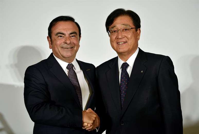 O presidente da Nissan, Carlos Ghosn (esquerda) e o presidente da Mitsubishi Motors, Osamu Masuko, comemoram parceria das empresas em Tóquio.