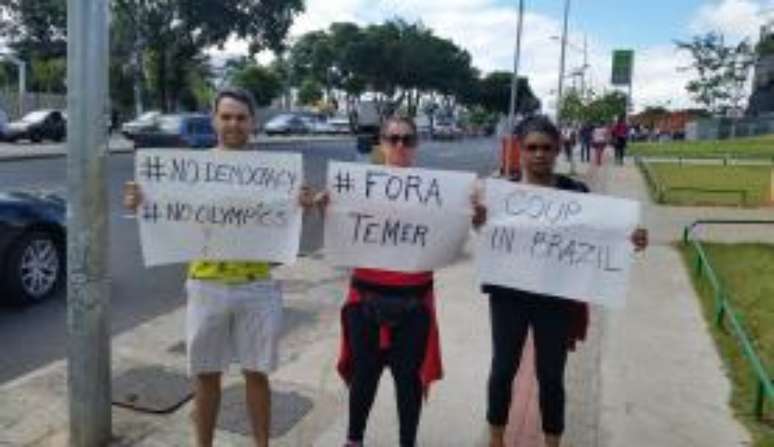 Manifestantes exibem cartazes contra o impeachment de Dilma Rousseff no idioma inglês