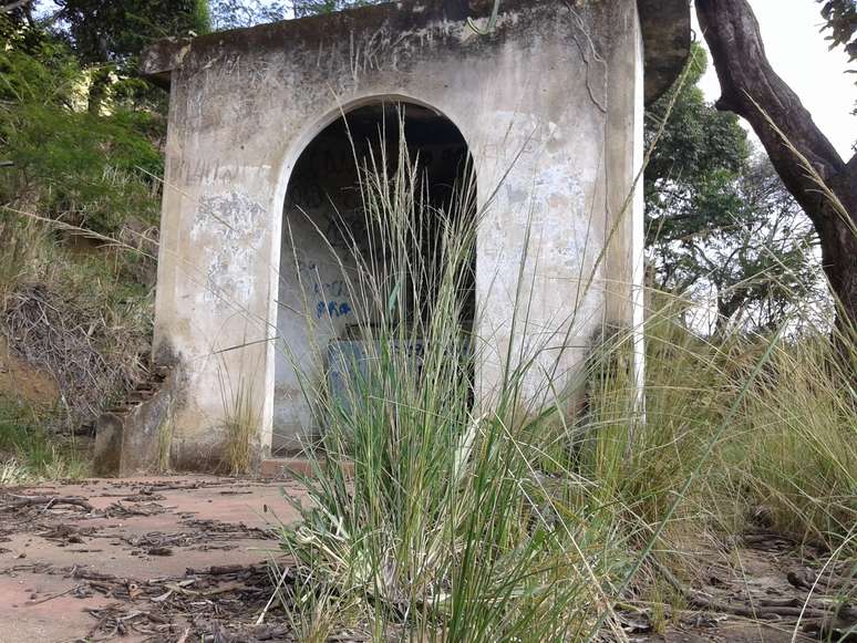 Paredes semidestru&iacute;das e mato alto simbolizam o descaso com a Capelinha de Nossa Senhora de F&aacute;tima
