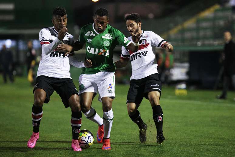 Dener (no centro), da Chapecoense, tenta passar pela marcação de Leonardo Moura e João Paulo, do Santa Cruz