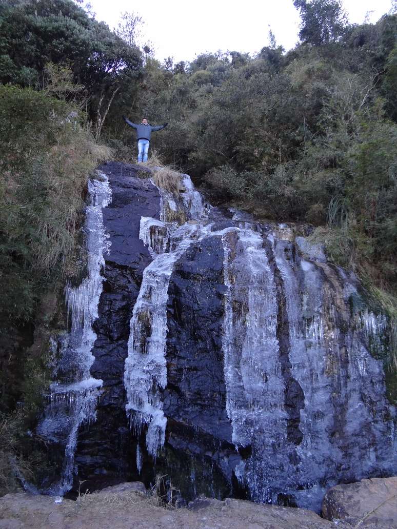 Turista escala cachoeira congelada em Urupema, na região serrana de Santa Catarina