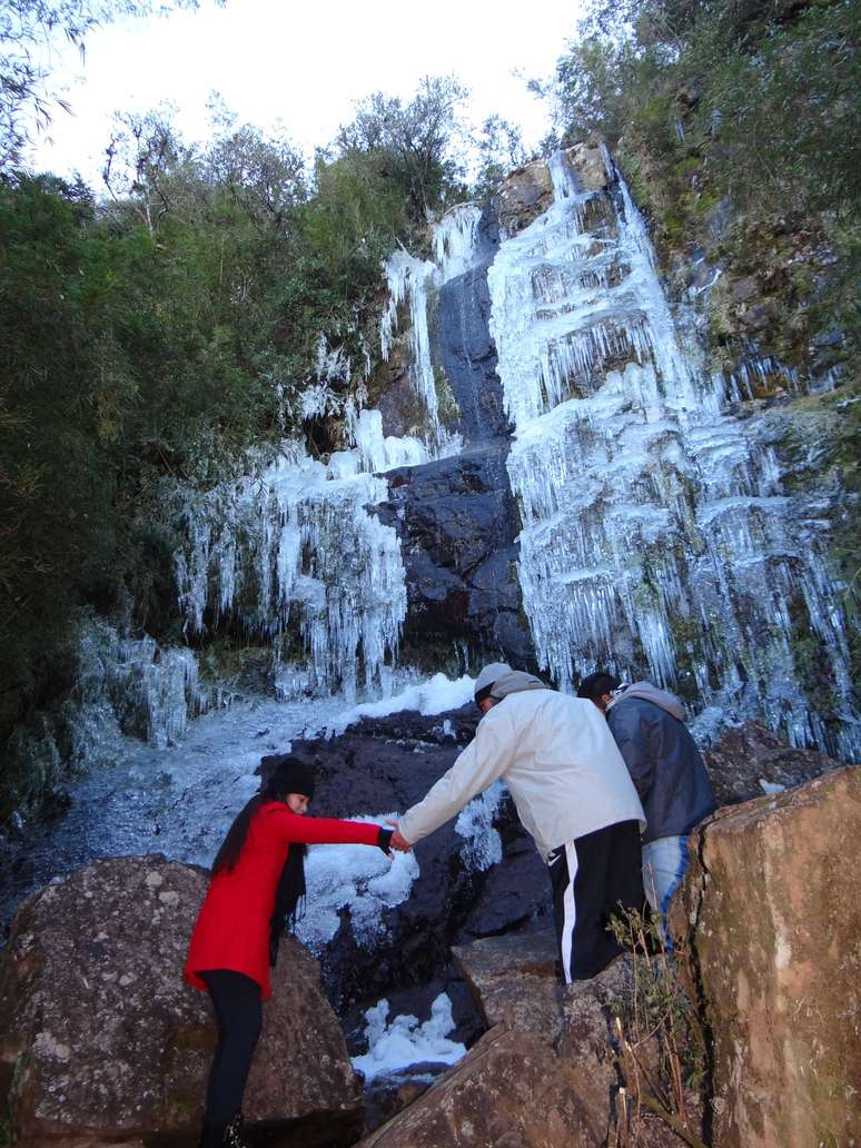 Turistas escalam cachoeira congelada em Urupema, na região serrana de Santa Catarina