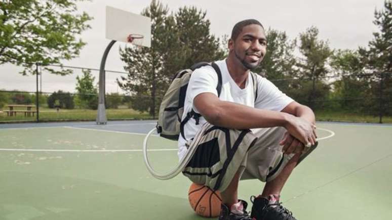 Stan Larkin na quadra de basquete, com o coração artificial e o Freedom Driver em uma mochila