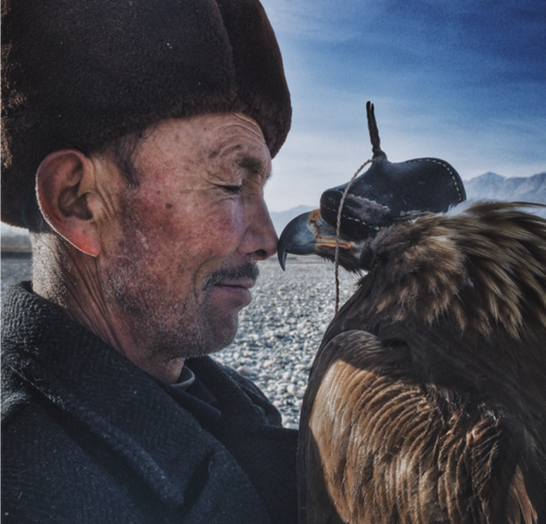 Siyuan Niu, da China, ganhou o prêmio principal do Ippaward, concurso de fotos registradas com iPhone, como esse registro, batizado &#034;O homem e a águia&#034;. &#034;Os valentes e sábios khalkas vivem nas montanhas no sul da província de Xinjiang&#034;, explica. &#034;Eles veem as águias como seus filhos. Elas são treinadas para a caça. Este homem de 70 anos age de forma rígida e solene com sua família e amigos, mas esboça um sorriso quando está com sua águia.&#034;