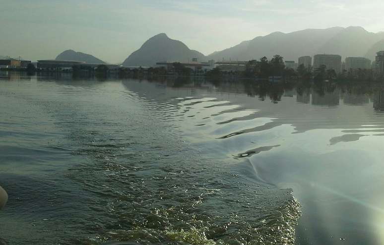 As águas da Lagoa de Jacarepaguá chegam a ficar gelatinosas por causa do esgoto; ao fundo, o Parque Olímpico