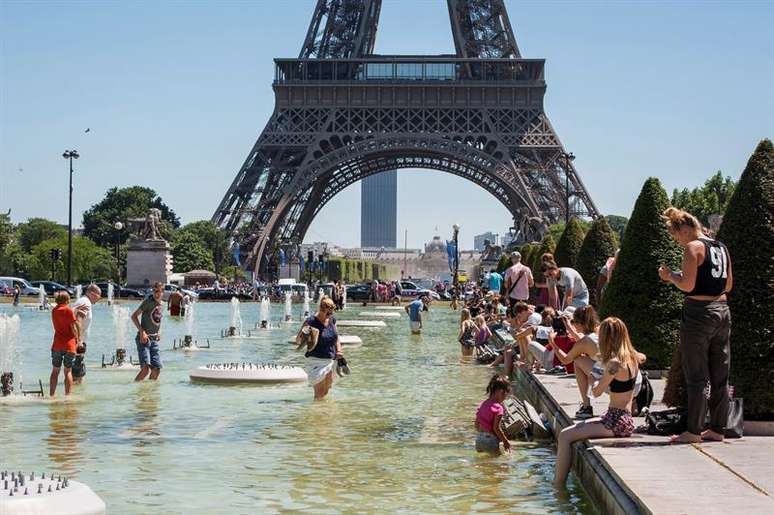 Multid&atilde;o se refresca nas fontes dos jardins da Torre Eiffel, em Paris. A ag&ecirc;ncia meteorol&oacute;gico alertou para as altas temperaturas em boa parte da Fran&ccedil;a. Imagem de 19 de julho de 2016. 