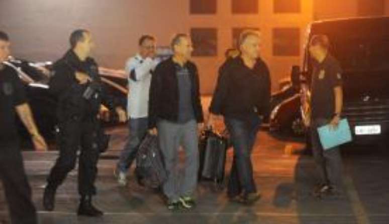 O ex-diretor da Delta Cláudio Abreu (de branco), o empresário Adir Assad (de jaqueta) e o empresário Carlinhos Cachoeira (de preto) entrando na viatura da Polícia Federal após depoimento 