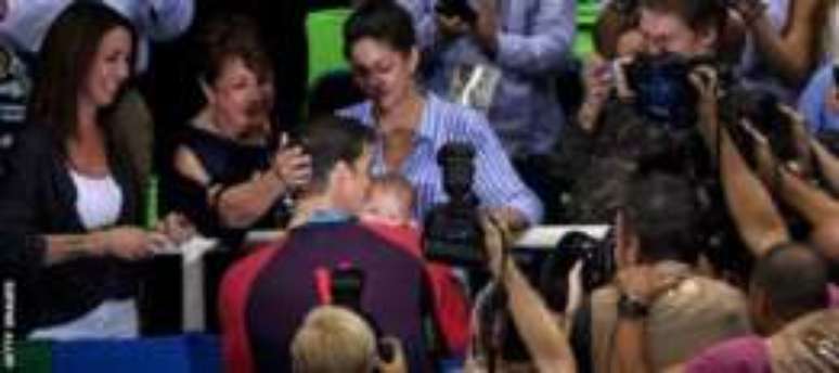 Nicole e o filho de três meses, Boomer, ficam nas arquibancadas no Rio para assistir a cada prova de Phelps