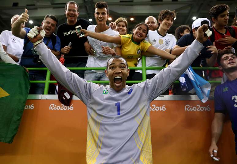 O goleiro Maik, da Seleção Brasileira de handebol, tira uma foto junto aos torcedores brasileiros