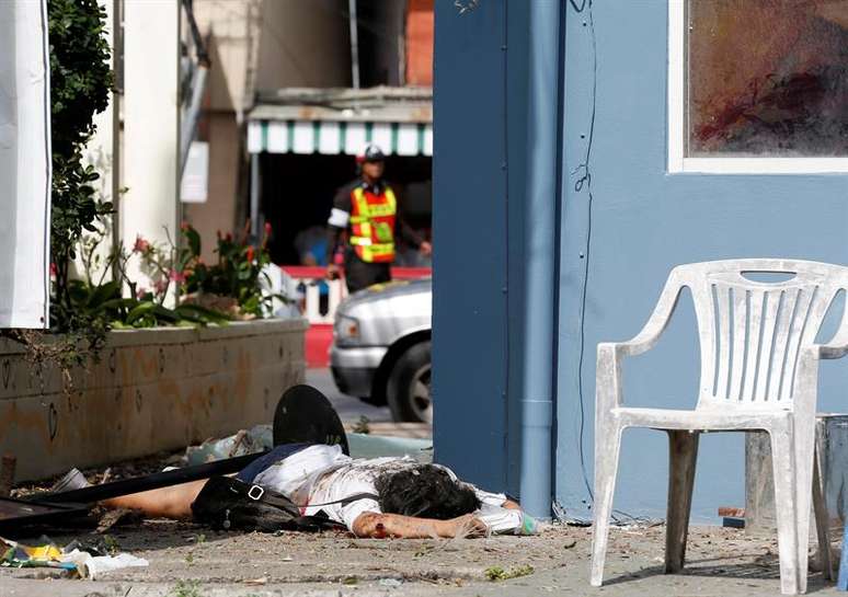 Pessoa ferida aguarda socorro ap&oacute;s explos&atilde;o em atentado na Til&acirc;ndia