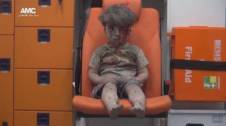 Omran Daqneesh, de cinco anos, em ambulância; imagem simboliza sofrimento humano na Síria após 5 anos de guerra civil