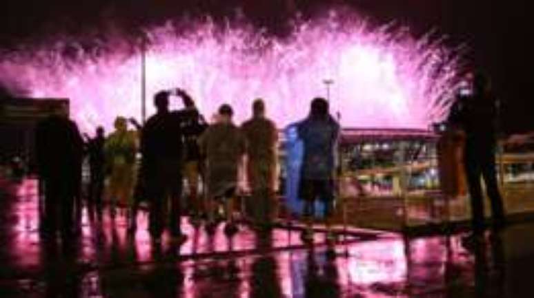 Grupo assiste a queima de fogos do encerramento da Olimpíada do lado de fora do Maracanã; cidade recebeu 1 milhão de turistas, que gastaram R$ 4 bi