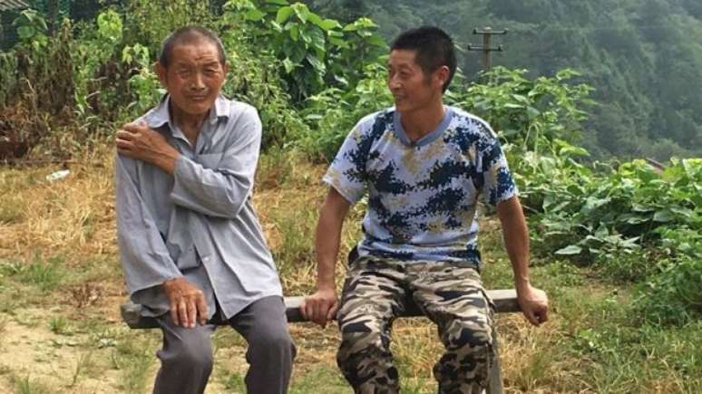 O tio (à esq.) foi o motivo que fez Xiong permanecer no vilarejo