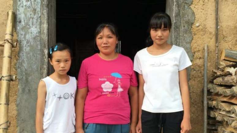 BBC Image caption Wang Caifeng, de 39 anos, e suas filhas moram em Laoya